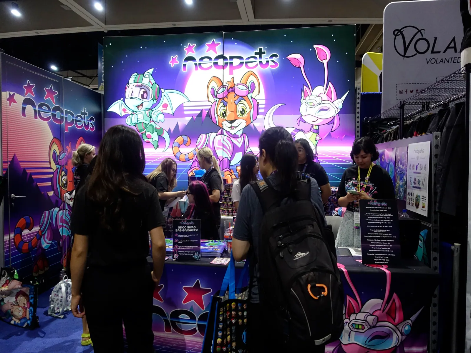 Visitors crowd around the purple vaporwave Neopets booth at San Diego Comic-Con 2023.